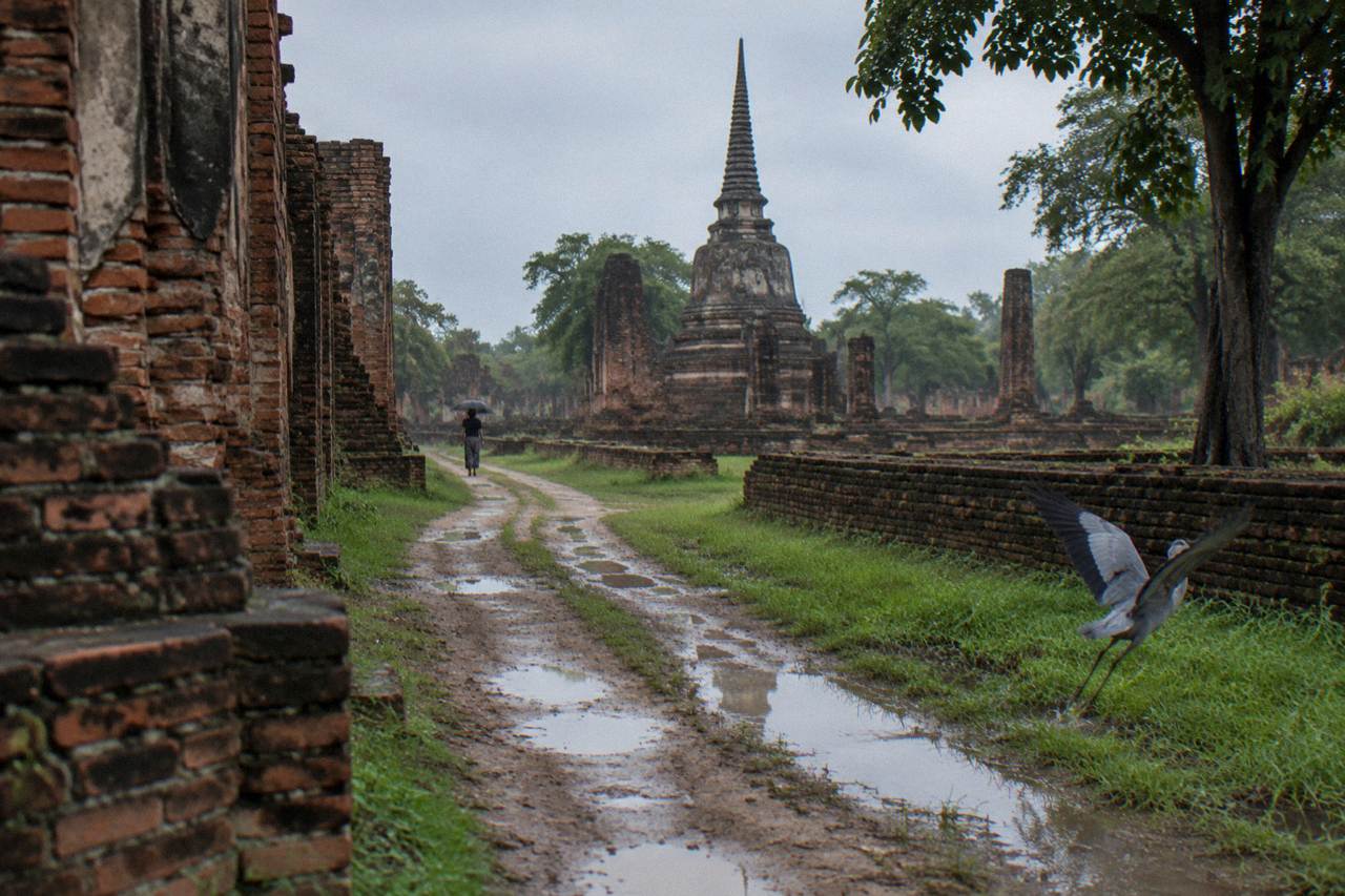 Bicycles parked beside weathered brick temple ruins under a wide sunny sky