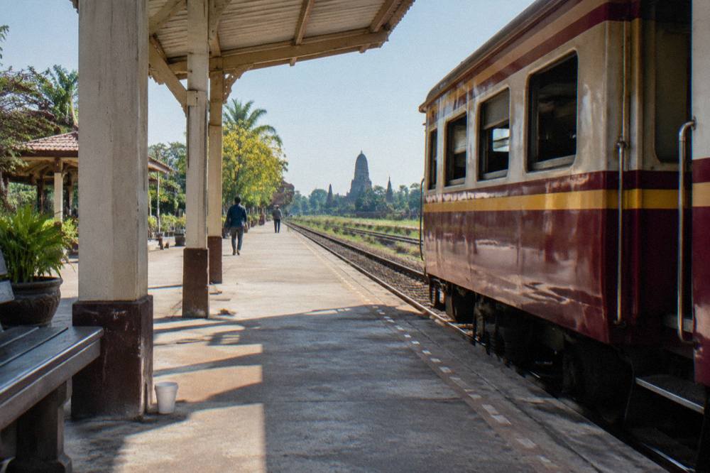 Red-and-gold train carriage at a station platform beside tracks