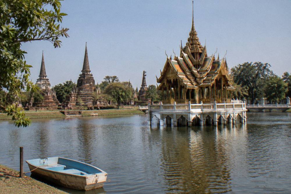 A ornate Thai royal pavilion standing on stilts in a ornamental lake
