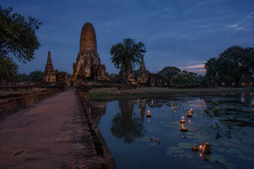 An empty Ayutthaya temple causeway under a wide evening sky at dusk