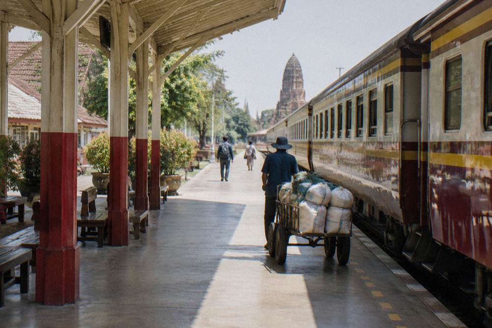 Modern commuter train standing at a bright Bangkok railway station platform