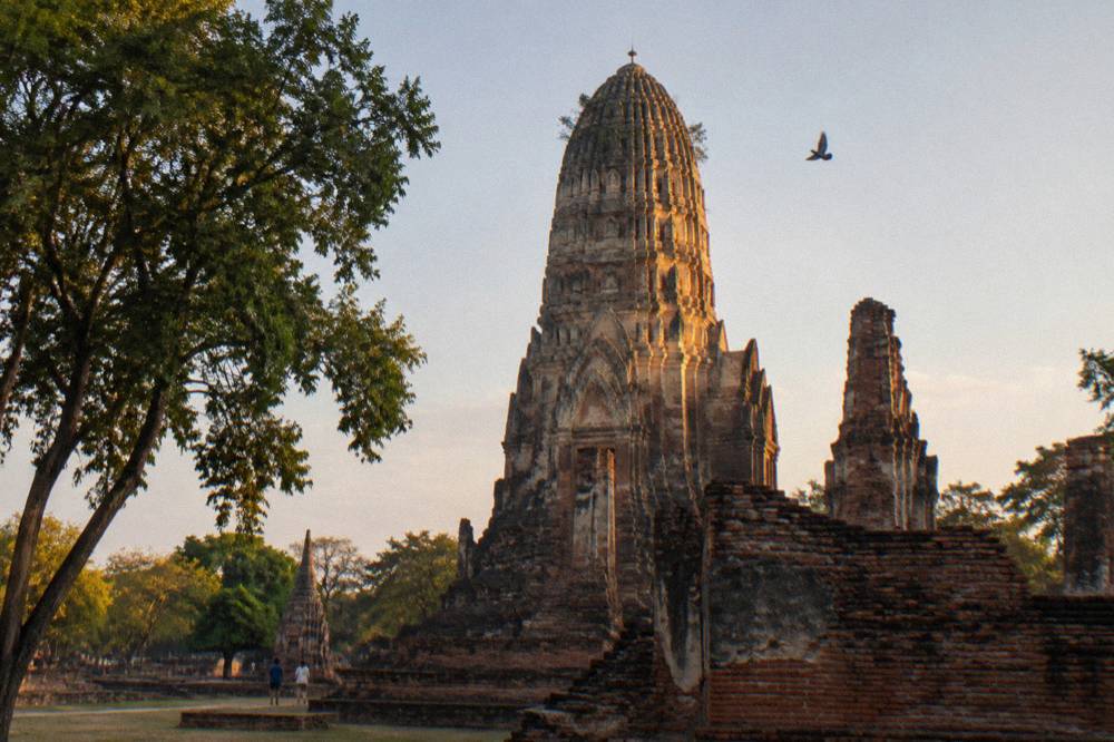 Tall brick chedi towers of an ancient temple complex in warm late afternoon light