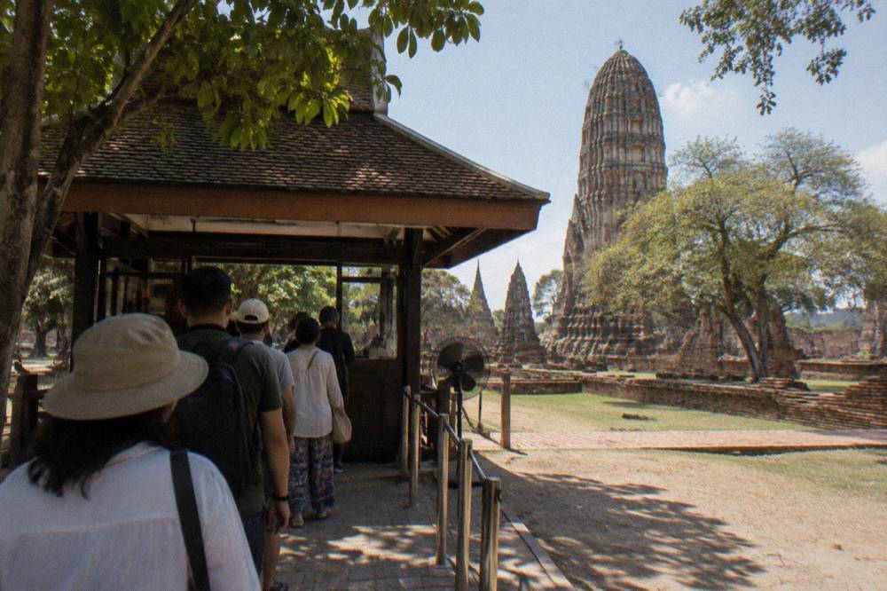Temple ticket booth with a small queue of visitors at a ruin entrance