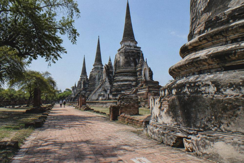 Rows of brick temple towers and a stone pathway through ruined temple grounds