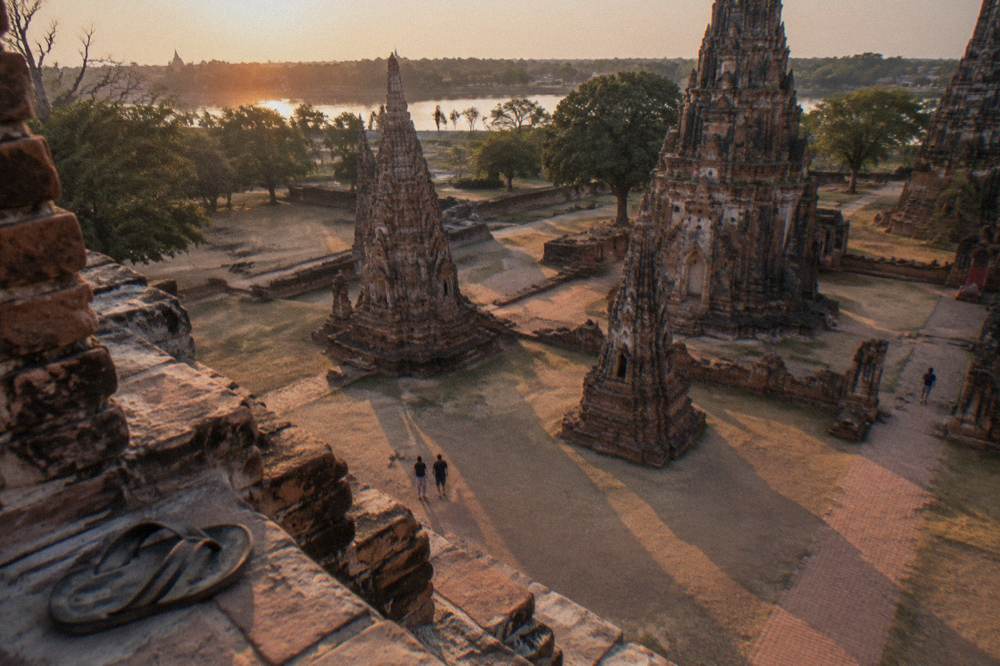 Long shadows stretching from small brick towers across a temple courtyard in low light