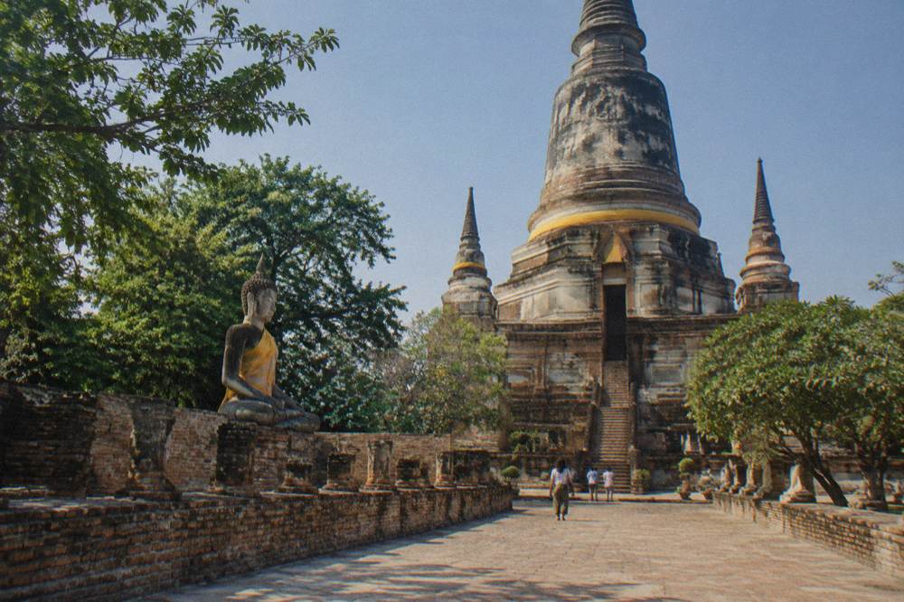 A wide stone terrace and brick pagoda standing in open sunlight with no shade